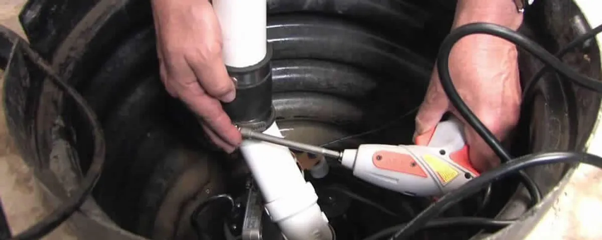 Sump pump installation technician connecting PVC discharge piping in Knoxville, TN